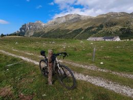 ein-fahrrad-das-an-einem-pfosten-auf-einem-feld-lehnt-hK1iRuwRiak
