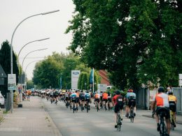eine-gruppe-von-radfahrern-die-eine-strasse-hinunterrasen-24vczdAuk-M
