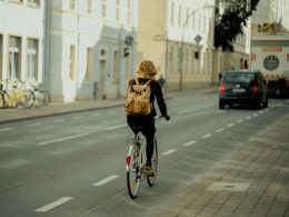 frau-in-schwarzer-jacke-fahrt-tagsuber-fahrrad-auf-der-strasse-hfhra5dsnXg