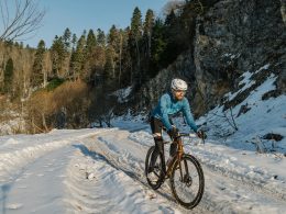 ein-mann-fahrt-mit-dem-fahrrad-eine-schneebedeckte-strasse-hinunter-sMP5cn7-Lz8