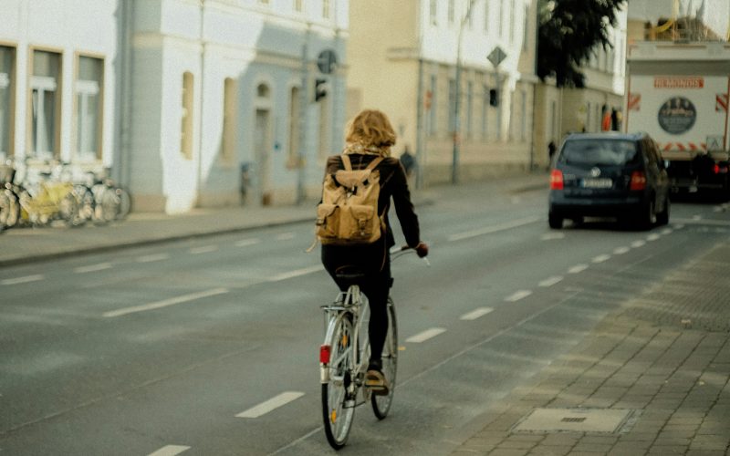 frau-in-schwarzer-jacke-fahrt-tagsuber-fahrrad-auf-der-strasse-hfhra5dsnXg